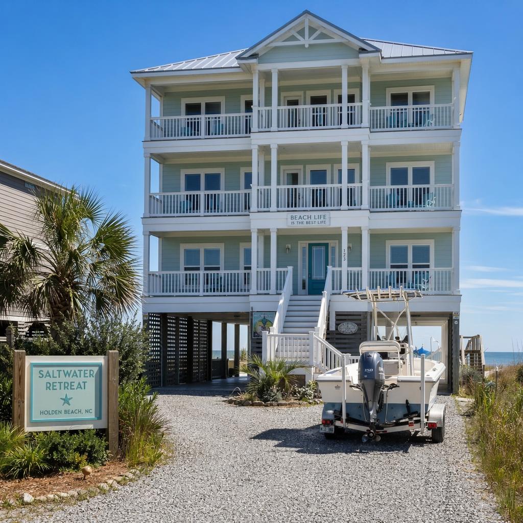 Large Group Vacation Rental - Book direct. Skip the fees. Three-story beach house with white railings and balconies, under a blue sky; sign reads 'Saltwater Retreat' Holden Beach, NC.